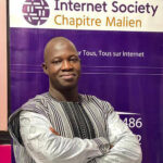 a man standing with his arms crossed in front of a banner for the Internet Society Chapitre Malen